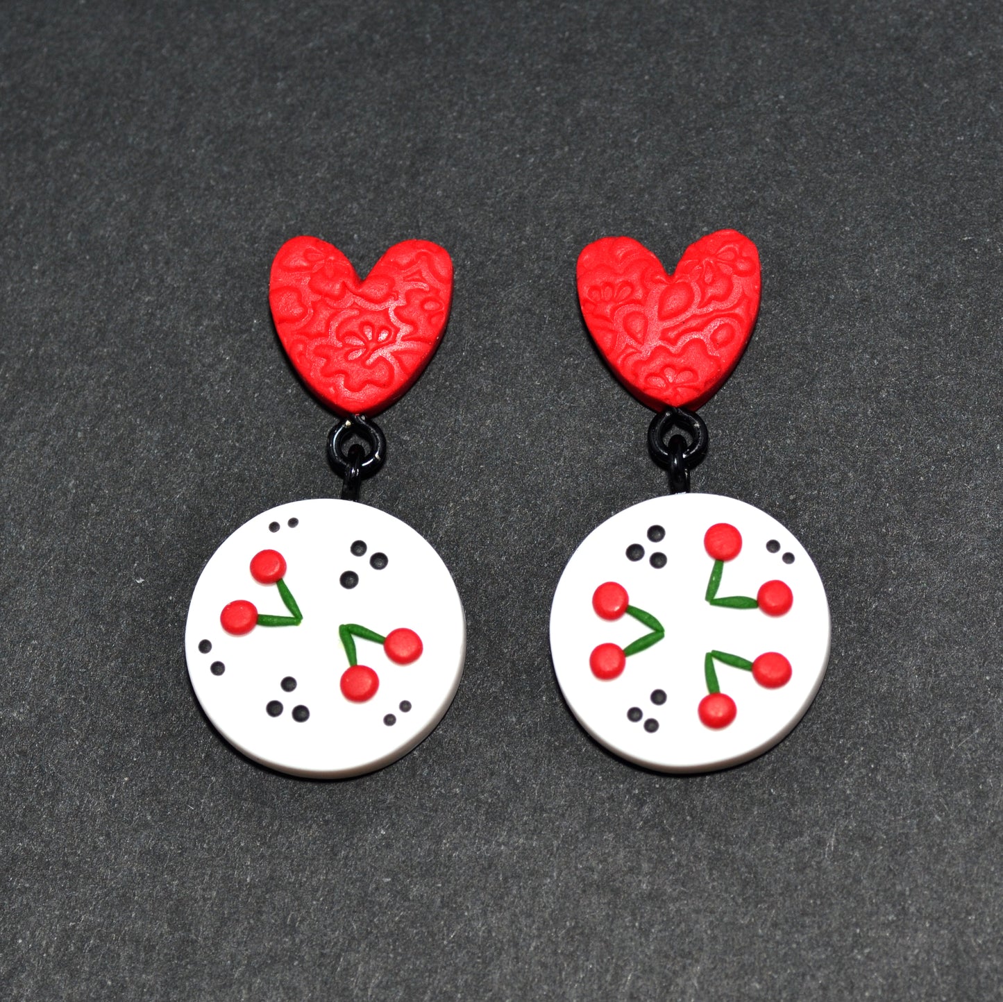 Γλυπτά κρεμαστά σκουλαρίκια κερασάκια σε λευκό φόντο και κόκκινες καρδιές από πολυμερικό πηλό