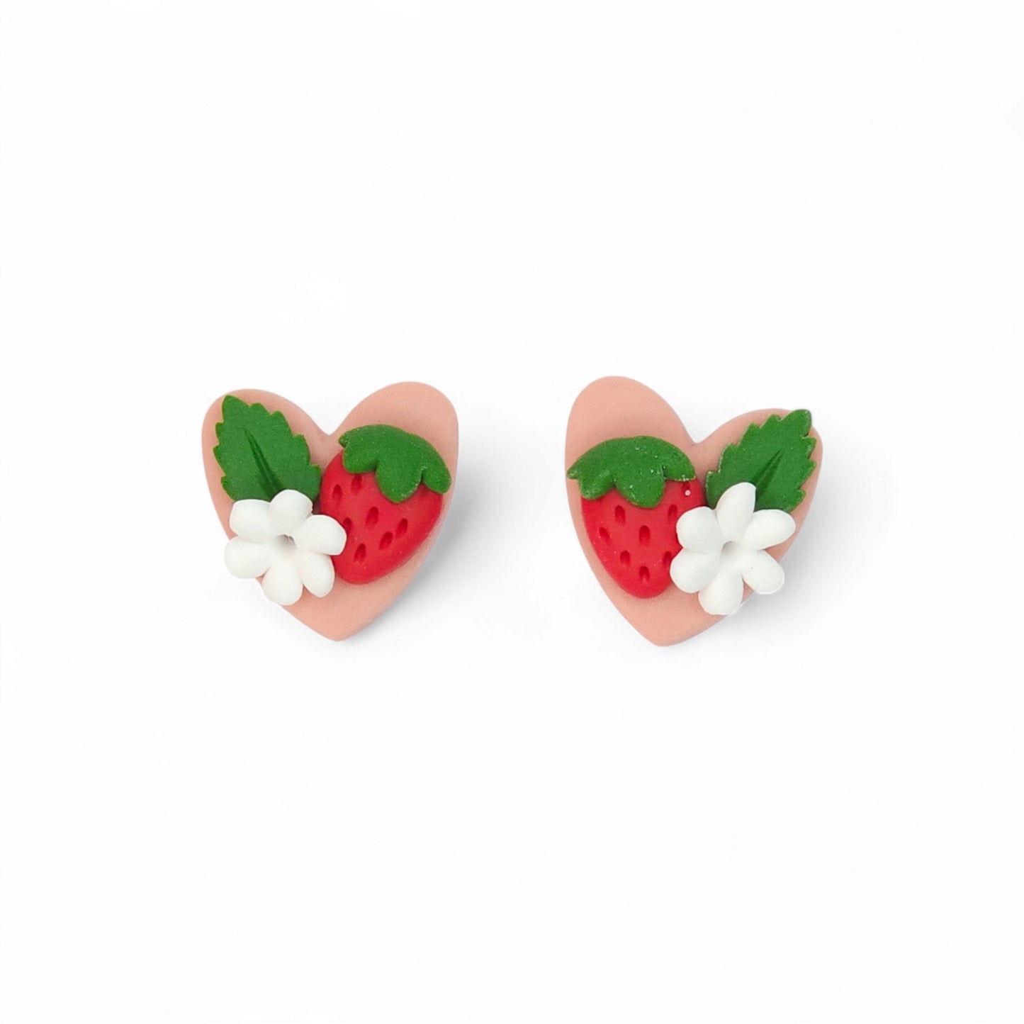Καρφωτά σκουλαρίκια καρδούλες κόκκινες φραουλίτσες σε απαλό ροζ φόντο από πολυμερικό πηλό