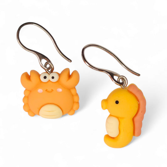 Ανόμοια κρεμαστά σκουλαρίκια πορτοκαλί ιππόκαμπος και καβουράκι