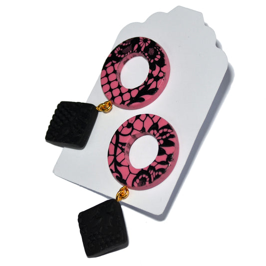 Καρφωτά σκουλαρίκια σε μοντέρνο κόψιμο με δαντελένια μαύρη μεταξοτυπία σε ροζ φόντο